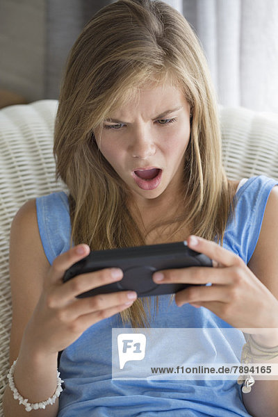 Mädchen schaut geschockt beim Spielen von Videospielen
