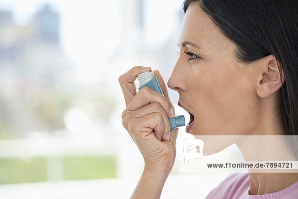Nahaufnahme einer Frau mit einem Asthma-Inhalator