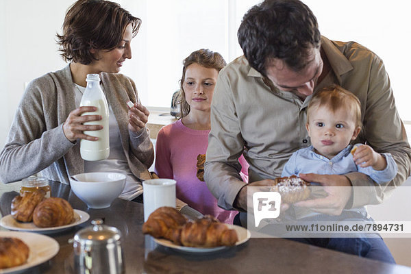 Familie beim Frühstück an der Küchenzeile