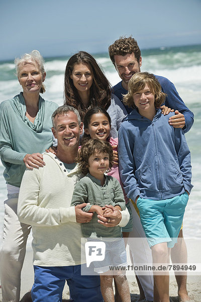 Porträt einer am Strand lächelnden Familie