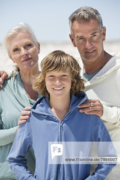 Porträt eines Jungen mit seinen Großeltern am Strand