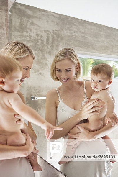 Reflektion einer Frau und ihres Babys im Spiegel