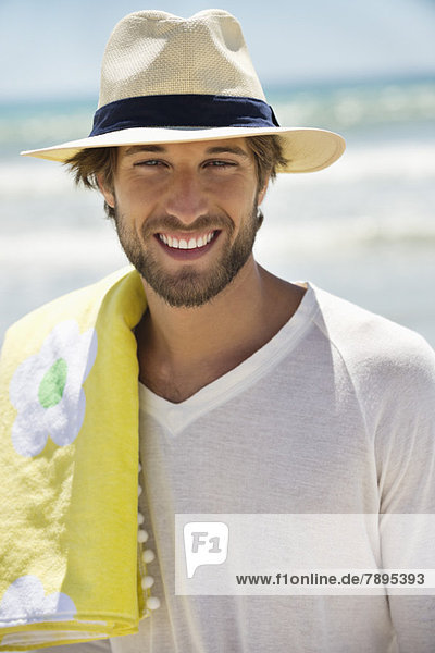 Porträt eines am Strand lächelnden Mannes