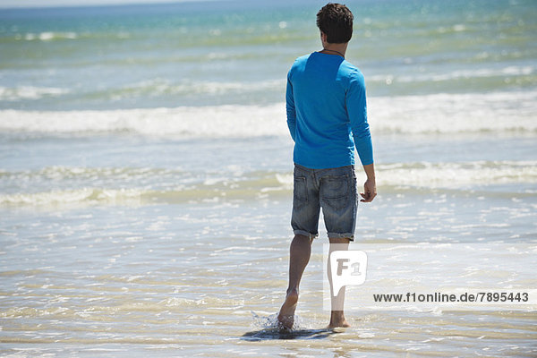 Man standing on the beach and looking at the sea