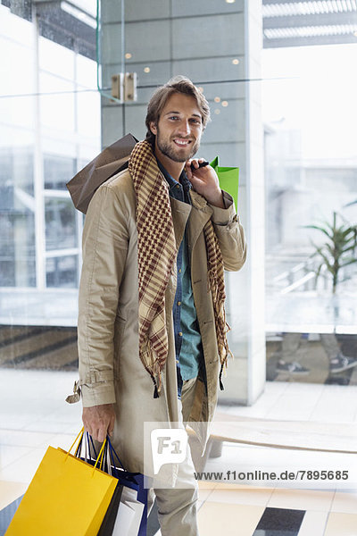 Porträt eines lächelnden Mannes mit Einkaufstaschen