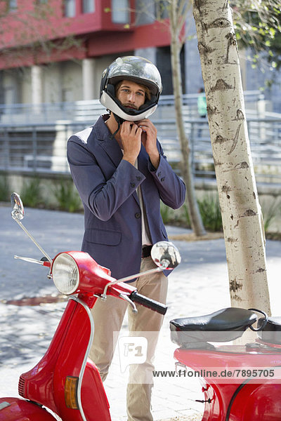 Man standing near a scooter on a street