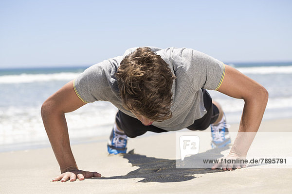 Mann trainiert am Strand