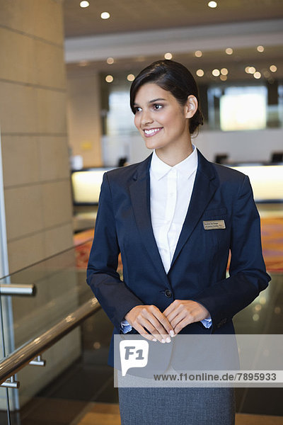 Receptionist standing in a hotel lobby and smiling