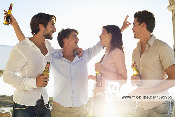 Vier Freunde genießen Bier auf der Party