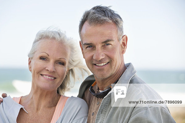 Porträt eines am Strand lächelnden Paares