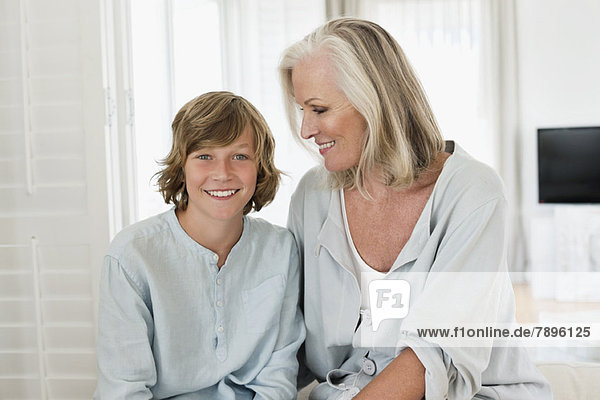 Bildnis eines Jungen  der mit seiner Großmutter sitzt und lächelt