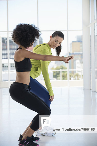 Woman exercising with her instructor in a gym