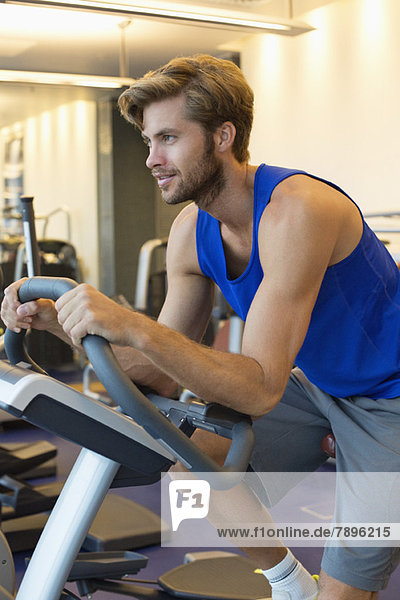 Man on an exercise bike in a gym