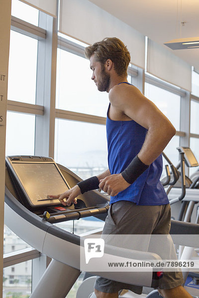 Man running on a treadmill in a gym