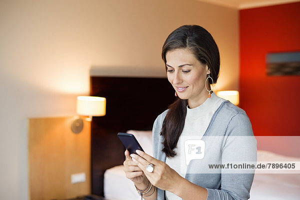 Woman using a cell phone in a hotel room