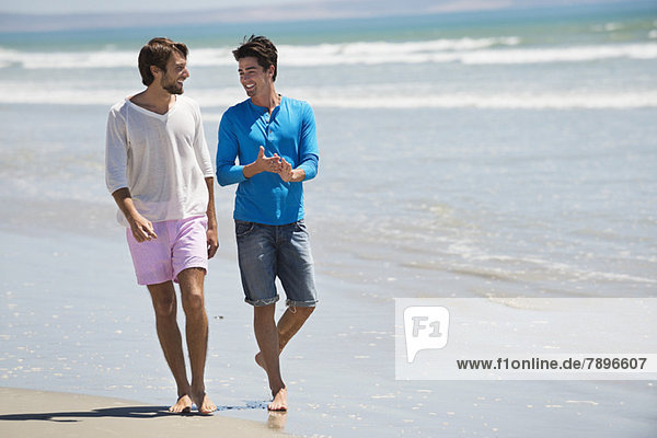Two men walking on the beach