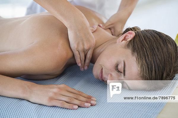 Frau erhält Rückenmassage von einem Massagetherapeuten