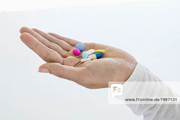 Close-up of a woman's hand holding medicines
