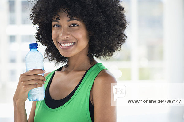 Smiling woman drinking water from a bottle