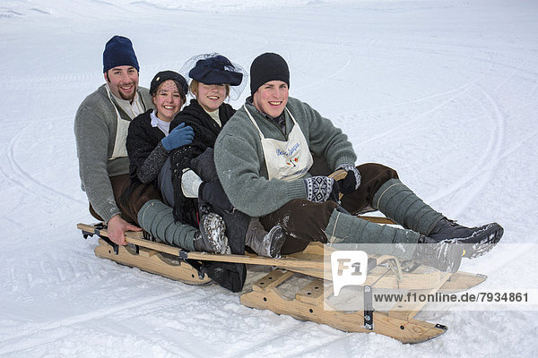 Historical bob race Belle Époque  bobsleigh  replica from 1911  mixed team wearing traditional clothes