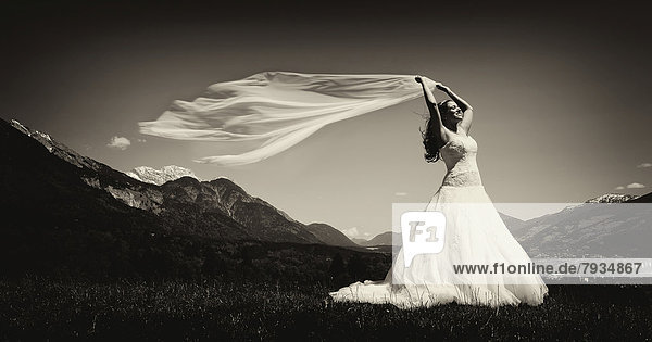 Bride holding a flowing scarf in the Tyrolean Alps