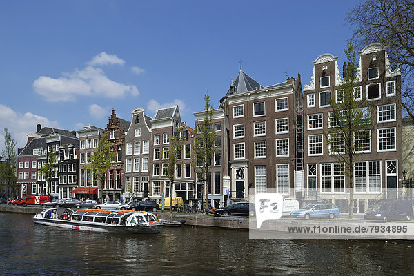 Historical merchants' houses on the Herengracht in the historic centre  tourist boat at front