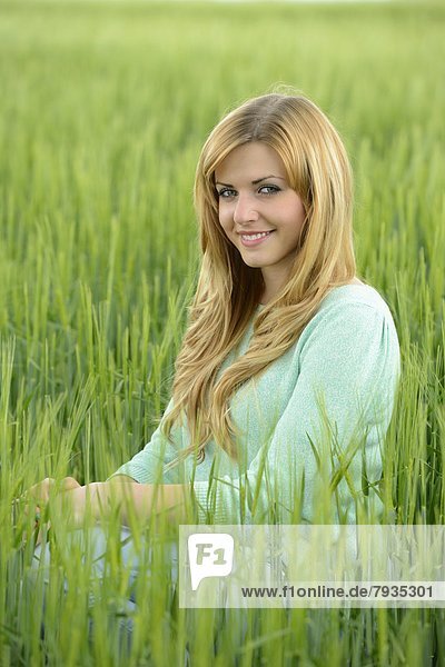 Blond young woman in a cornfield