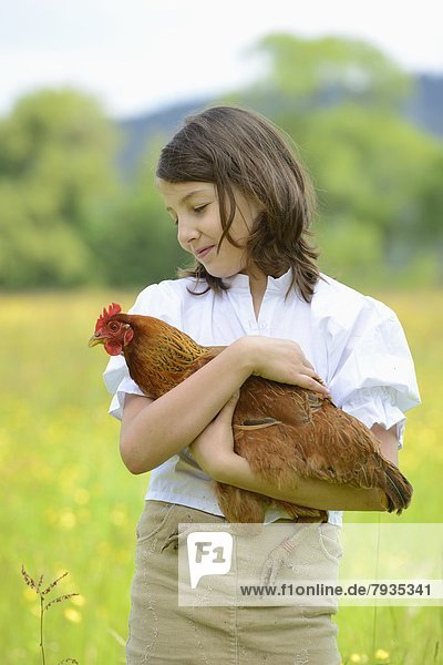 Mädchen hält ein Huhn