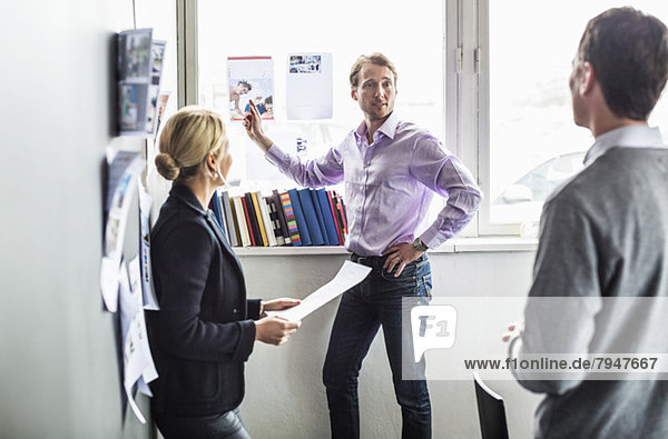 Business colleagues discussing over photograph in office