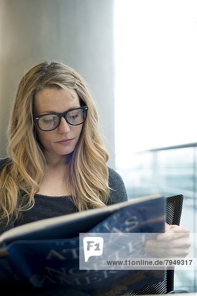 A young woman reads in a library.