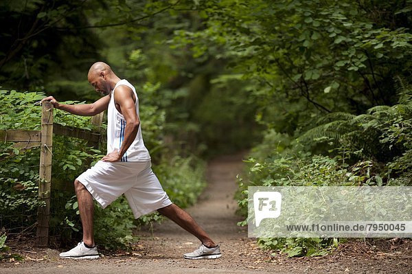 Young african american man stretching at trailhead