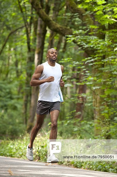 Young african american man running in city park