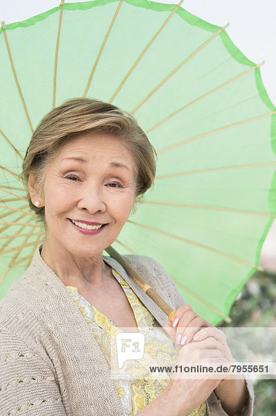 Senior  Senioren  Portrait  Frau  grün  halten  Sonnenschirm  Schirm