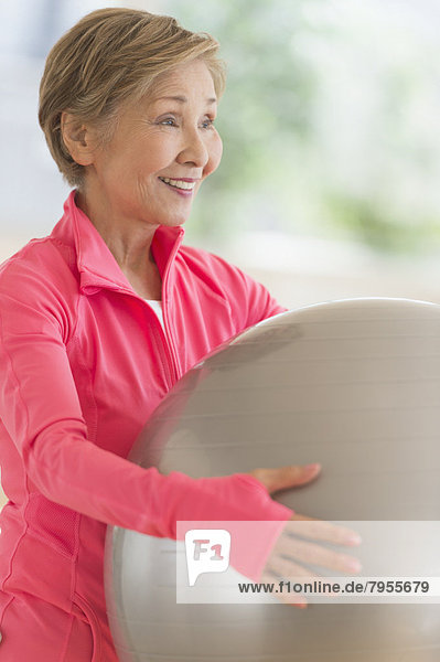 Senior woman exercising with fitness ball