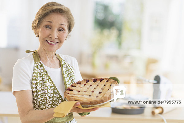 Senior woman holding freshly baked cake