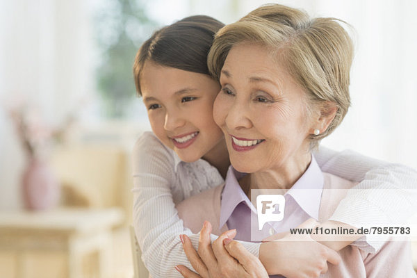 Granddaughter (8-9) embracing grandmother