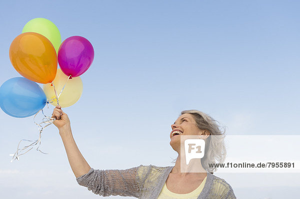 Farbaufnahme  Farbe  Senior  Senioren  Frau  Luftballon  Ballon  Bündel  halten