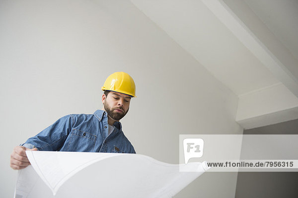 Portrait of construction worker looking at blueprints