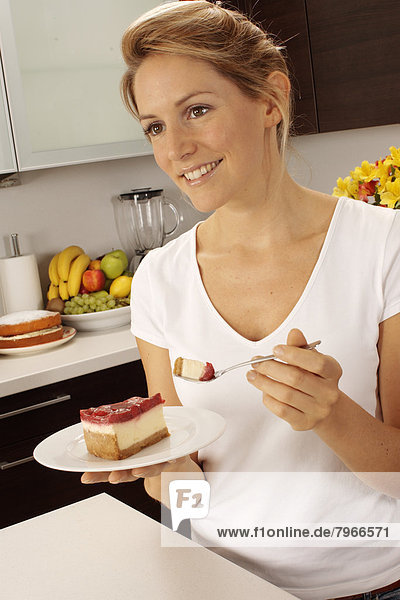 Frau Küche essen essend isst Käsekuchen