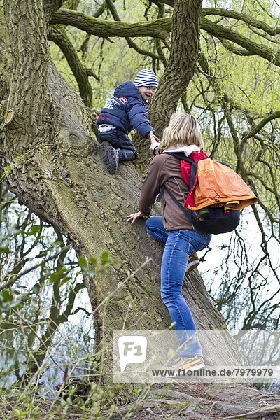 Deutschland  Kiel  Mutter und Sohn klettern am Baum