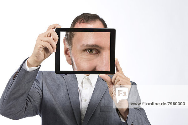 Portrait of businessman photographing self using digital tablet  close up