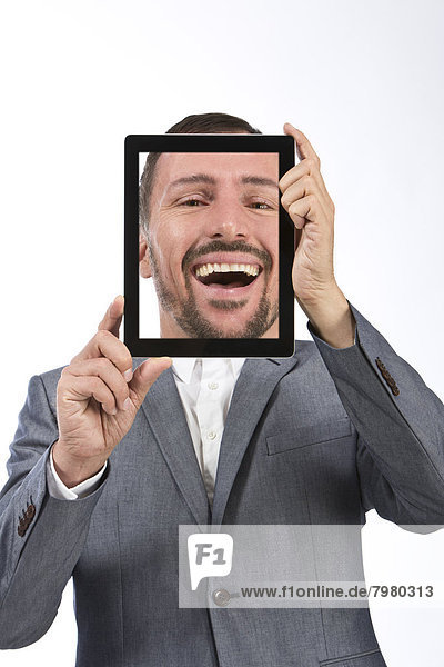 Portrait of businessman photographing self using digital tablet  smiling