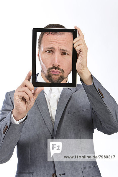 Portrait of businessman photographing self using digital tablet  close up