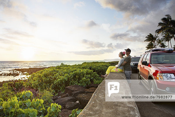 USA  Hawaii  Mittleres erwachsenes Paar bei Sonnenuntergang am Strand