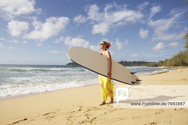 USA  Hawaii  Frau stehend mit Surfbrett am Strand