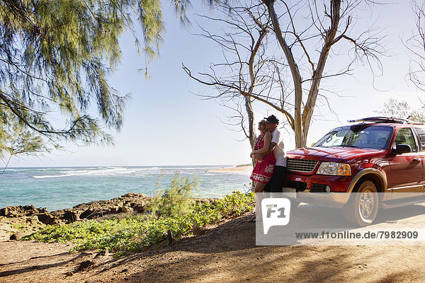 USA  Hawaii  Mittleres erwachsenes Paar in der Nähe eines Autos
