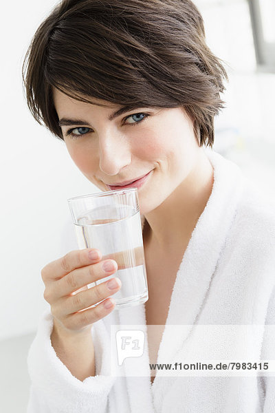Portrait of young woman holding water glass  close up
