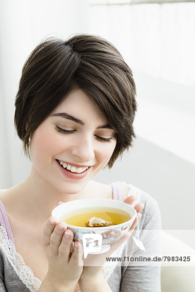 Young woman holding tea cup  smiling