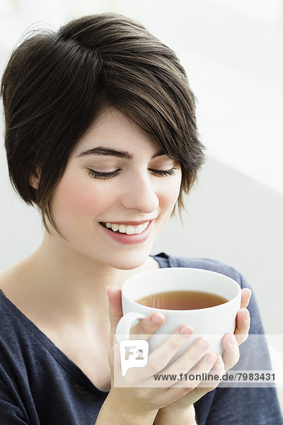 Young woman holding tea cup  close up