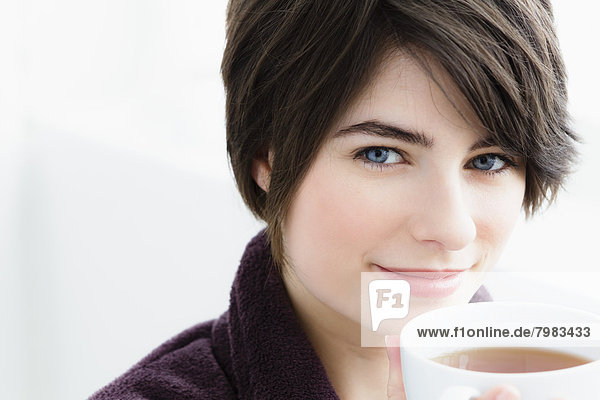 Portrait of young woman holding tea cup  close up